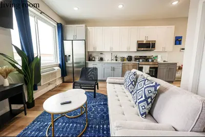 a living room with a couch and a table and a kitchen at Central 1BR1BAKing BedWiFiWD in Philadelphia