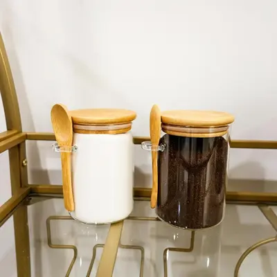 two mason jars with wooden handles sitting on a glass table at 1Bed1Bath-CentralKingBed,WD,WIFI in Philadelphia