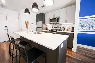 a kitchen with a large white counter top and chairs at Modern 1BD AptWiFi,Gym,Washer in Philadelphia