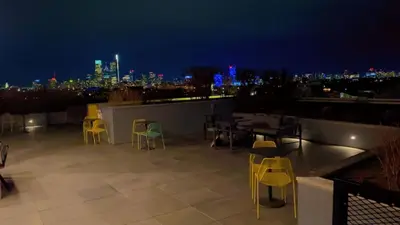 a rooftop patio with tables and chairs at night at Modern 1BD AptWiFi,Gym,Washer in Philadelphia