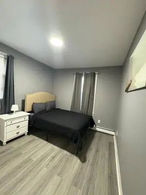 a bedroom with a bed and a dresser in it at 4 bedroom apartment by Ewr Airport in Newark