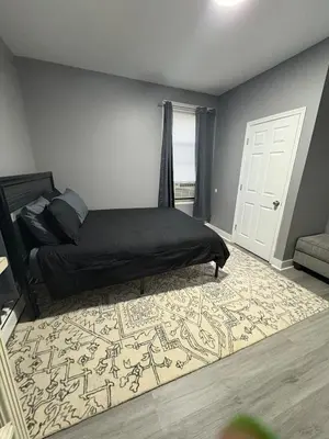 a bedroom with a bed and a rug on the floor at 4 bedroom apartment by Ewr Airport in Newark