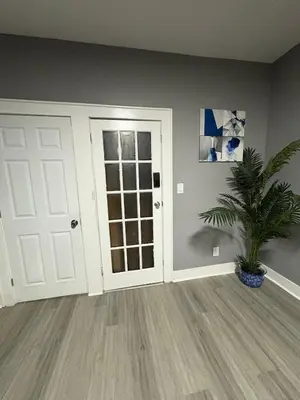 a room with a white door and a potted plant at 4 bedroom apartment by Ewr Airport in Newark