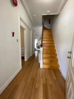 a hallway with a wooden staircase in a house at C Jay Homes 6 minutes Walk to Journal square in Jersey City