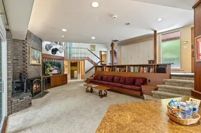 a living room with a red couch and a staircase at Nature's Retreat 4-Bedroom Cabin in Honesdale