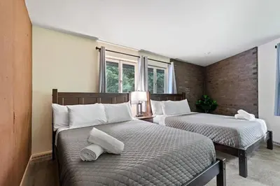 a bedroom with two beds with white pillows at Nature's Retreat 4-Bedroom Cabin in Honesdale