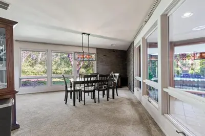 a dining room with a table and chairs and windows at Nature's Retreat 4-Bedroom Cabin in Honesdale