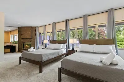two beds in a room with windows at Nature's Retreat 4-Bedroom Cabin in Honesdale