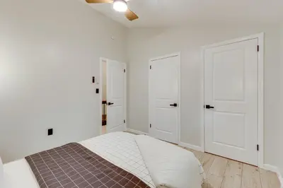 a white bedroom with a bed and two white doors at Lake Access at Family-Friendly Home in Tobyhanna in Tobyhanna