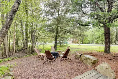 a group of chairs and a fire pit in the woods at Lake Access at Family-Friendly Home in Tobyhanna in Tobyhanna