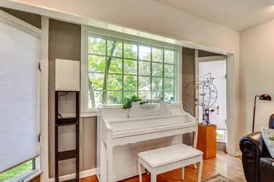a white piano in a living room with a window at 1 Mi to Campus Princeton Home with Furnished Deck in Princeton