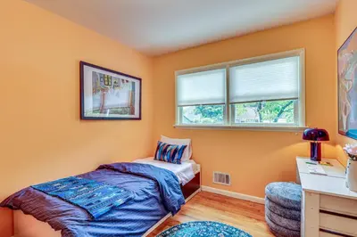 a bedroom with orange walls and a bed and a desk at 1 Mi to Campus Princeton Home with Furnished Deck in Princeton