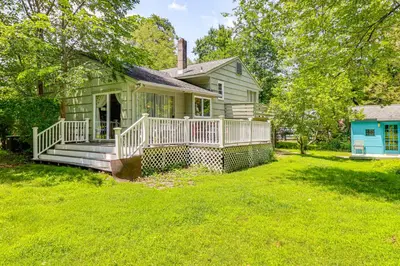 a green house with a porch and a yard at 1 Mi to Campus Princeton Home with Furnished Deck in Princeton