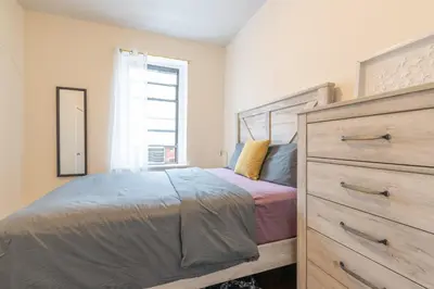 a bedroom with a bed with a dresser and a window at 5 Bedroom 2 Bath Full Floor Midtown in New York