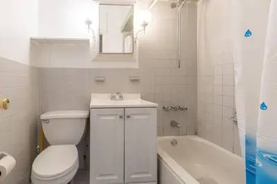a bathroom with a toilet and a sink and a tub at 5 Bedroom 2 Bath Full Floor Midtown in New York