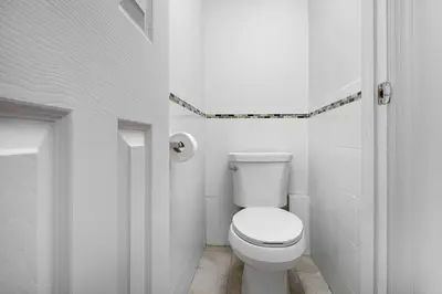 a white bathroom with a toilet in a room at Beautiful 3 Bedroom Unit in Prime Location in New York