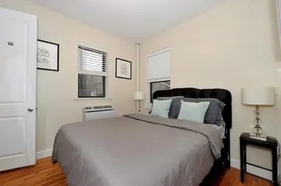 a bedroom with a large bed and two windows at Comfy 1 Bed 1 Bath Apartment in NYC in New York