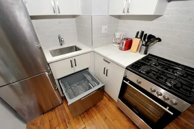 a small kitchen with a stove and a sink at Comfy 1 Bed 1 Bath Apartment in NYC in New York