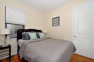 a bedroom with a bed with blue pillows and a window at Comfy 1 Bed 1 Bath Apartment in NYC in New York