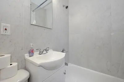 a white bathroom with a sink and a toilet at Comfy 1 Bed 1 Bath Apartment in NYC in New York