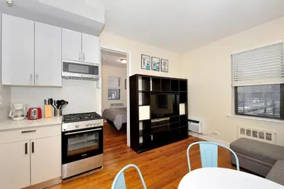 a kitchen and living room with a couch and a table at Comfy 1 Bed 1 Bath Apartment in NYC in New York