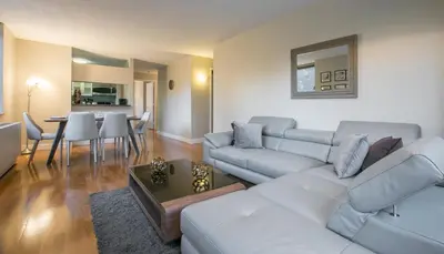 a living room with a white couch and a table at Fully Furnished 2BR 2Bath Unit in NYC in New York