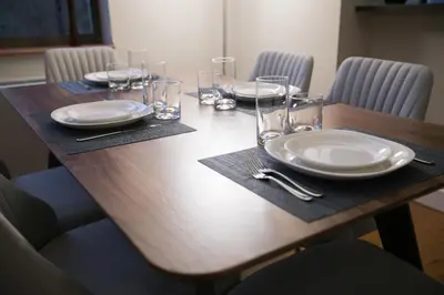 a wooden table with plates and glasses on it at Fully Furnished 2BR 2Bath Unit in NYC in New York