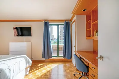 a bedroom with a bed and a desk and a window at Contemporary 2 Bed 2 Bath Apt Bright and Sunny in New York