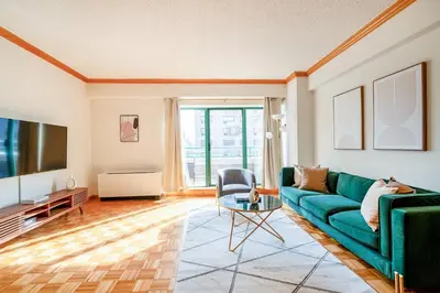 a living room with a green couch and a tv at Contemporary 2 Bed 2 Bath Apt Bright and Sunny in New York