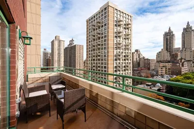 a balcony with chairs and tables and a view of a city at Contemporary 2 Bed 2 Bath Apt Bright and Sunny in New York