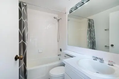 a bathroom with a sink and a toilet and a mirror at Contemporary 2 Bed 2 Bath Apt Bright and Sunny in New York
