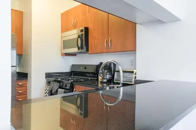 a kitchen with a sink and a microwave at Bright 2 Bedrooms 2 Bathrooms Unit in New York