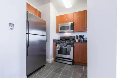 a kitchen with a stainless steel refrigerator and microwave at Bright 2 Bedrooms 2 Bathrooms Unit in New York