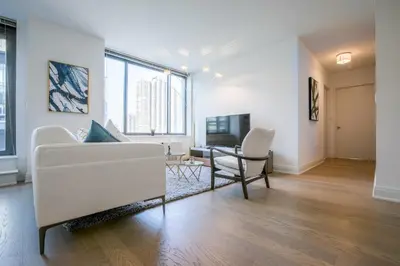 a living room with a white couch and a chair at Bright 2 Bedrooms 2 Bathrooms Unit in New York
