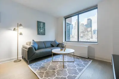 a living room with a couch and a table and a window at Fully Furnished 1BR in Murray Hills in New York