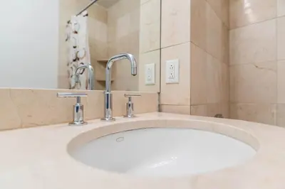 a bathroom with a white sink with a faucet at Fully Furnished 1BR in Murray Hills in New York