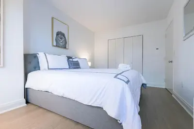 a bedroom with a large bed with white sheets at Fully Furnished 1BR in Murray Hills in New York