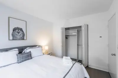 a bedroom with a white bed with a lion picture on the wall at Fully Furnished 1BR in Murray Hills in New York