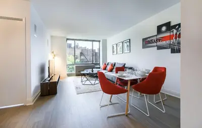 a living room with a dining table and red chairs at Beautiful 1 Bed Fully Furnished Apartment in New York