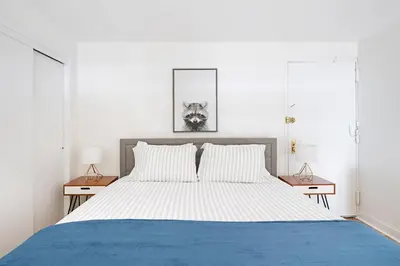 a bedroom with a blue and white bed with two lamps at Amazing Apartment for 2 1 Bed 1 Bath in New York