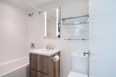 a bathroom with a sink and a toilet and a mirror at Amazing Apartment for 2 1 Bed 1 Bath in New York