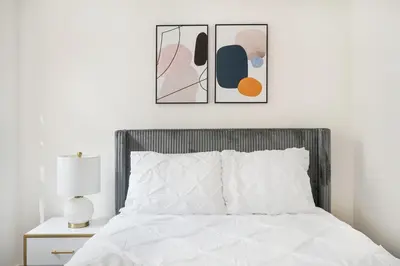 a bedroom with a bed with two pictures on the wall at 1 BR Gem in Prime Location of NYC in New York