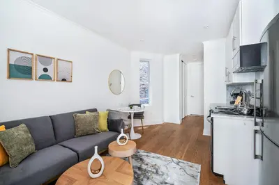 a living room with a couch and a kitchen at 1 BR Gem in Prime Location of NYC in New York