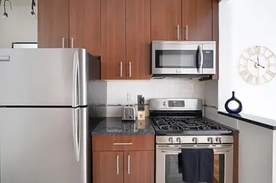 a kitchen with a white refrigerator and a stove top oven at Prime Upper west Side Location 1 Bedroom Apt in New York