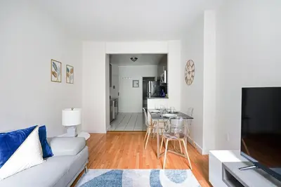 a white living room with a couch and a table at Prime Upper west Side Location 1 Bedroom Apt in New York