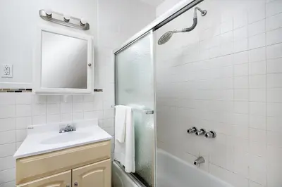 a white bathroom with a sink and a shower at Prime Upper west Side Location 1 Bedroom Apt in New York