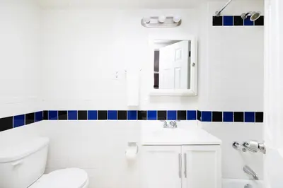 a bathroom with a white toilet and a sink at Contemporary 1 Bedroom Apartment in NYC in New York