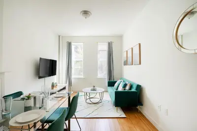 a living room with a green couch and a table at Contemporary 1 Bedroom Apartment in NYC in New York