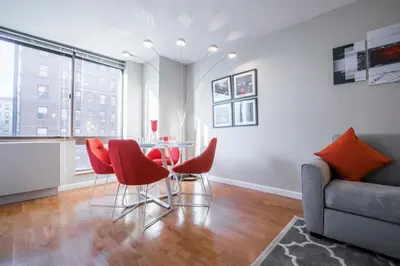 a living room with a table and chairs and a couch at Fully Furnished Studio Apartment in New York