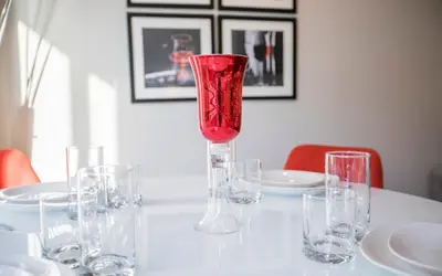 a white table with a red glass vase on it at Fully Furnished Studio Apartment in New York